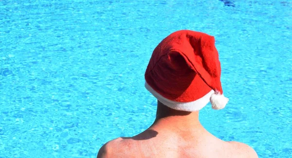 Een Man Met Een Kerstman Hoed Het Zwembad Het Concept — Stockfoto