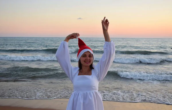 Een Meisje Een Kerstman Hoed Een Witte Jurk Een Achtergrond — Stockfoto