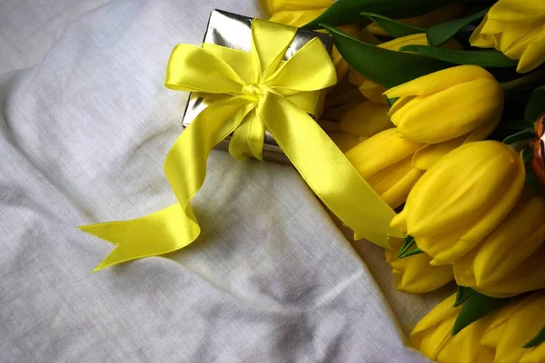 Sarı lale buketi ve bir hediye.