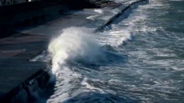 Deniz dalgaları sete çarpıyor. Beyaz köpük damlaları. Gerçek zamanlı çekim..