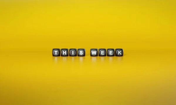Slova Tento Týden Bílém Textu Tmavých Dřevěných Blocích Prostém Žlutém — Stock fotografie