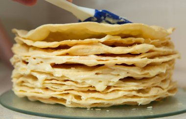 Making homemade Napoleon cake. Many layers of cake smeared with cream