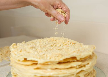 Making homemade Napoleon cake. The cake is sprinkled liberally with crumbs on top