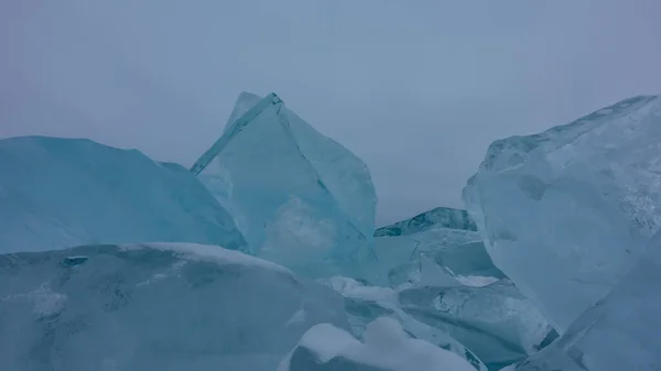 青绿色的冰块在雾蒙蒙的天空中飘扬 锋利的边缘 表面上的雪 贝加尔湖 — 图库照片