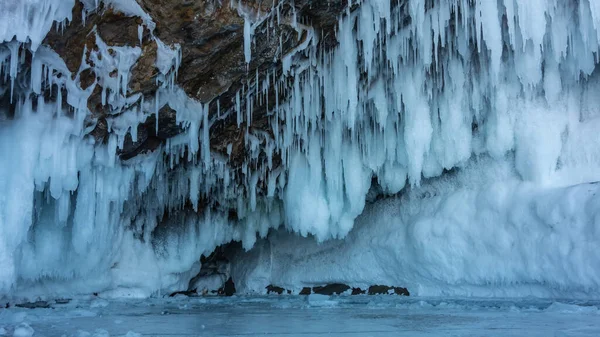 얼어붙은 지붕에는 종유석 고드름들이 줄지어 매달려 화강암 얼음의 클로즈업 바이칼호 — 스톡 사진
