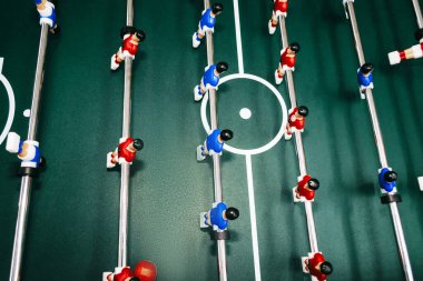 Kırmızı ve mavi figürlü masa futbolu yaklaşıyor.