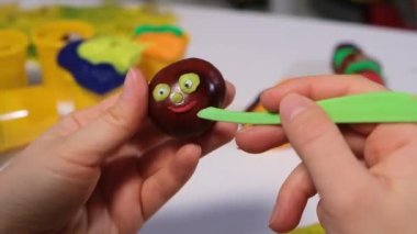 Bir kadın el işi tırtıllar için kestane üzerine heykel yapmak için hamurdan ağızlık yapar.