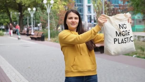 Bir Kadın Üzerinde Yazı Olan Bir Çanta Gösterir Artık Plastik — Stok video