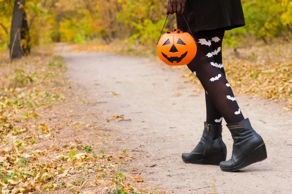 ハロウィンの森を歩くコウモリとタイツの女性の足 — ストック写真