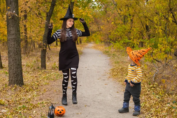 Madre e hijo bailan en disfraces de Halloween en el bosque de otoño —  Fotos de Stock