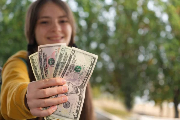 Дівчинка-підліток показує багато доларів і посміхається з місцем для тексту . — стокове фото