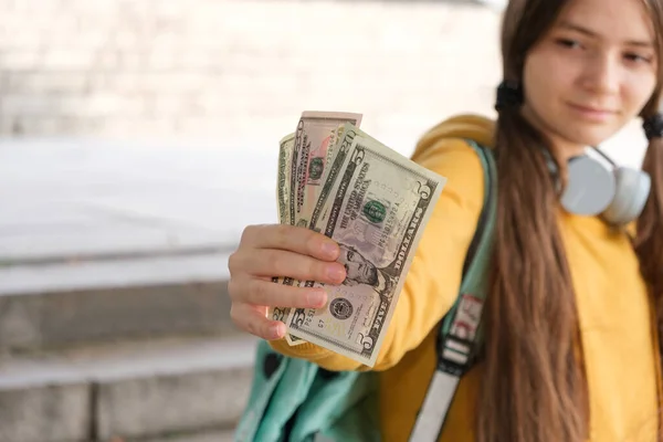 Дівчинка-підліток показує багато доларів і посміхається з місцем для тексту . — стокове фото
