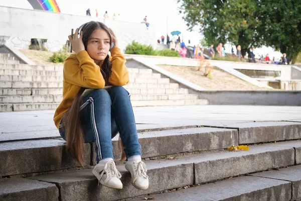 Una adolescente triste se sienta en las escaleras y se cubre la cabeza con las manos — Foto de Stock