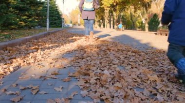 Annesi sonbahar yaprakları arasında parkta yürür, oğlu onu yakalar, arkasından koşar..