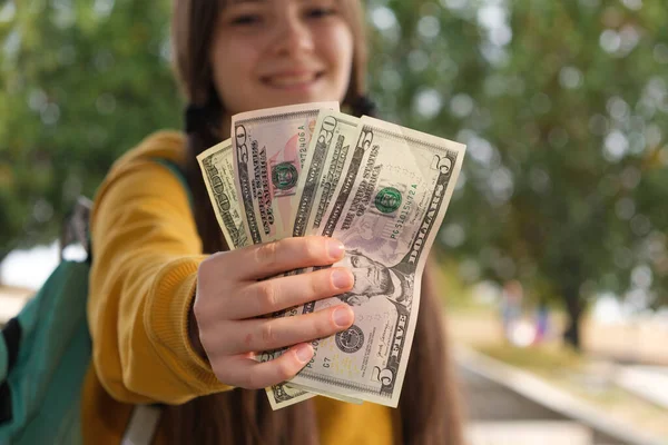 Дівчинка-підліток показує багато доларів купюр і посмішок . — стокове фото