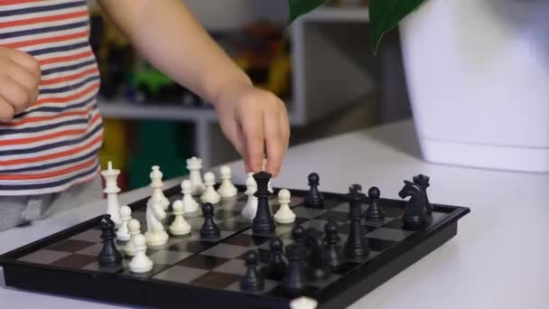 Madre e hijo juegan ajedrez, un primer plano del tablero de ajedrez, los caballeros se mueven. — Vídeo de stock