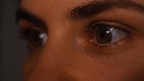En person ögon är närbild, en person tittar på TV och blinkar, en reflektion från en skärm — Stockvideo