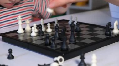 Anne ve oğlu satranç oynuyor, satranç tahtasının yakın çekimi.