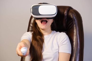 Sanal gerçeklik gözlüklü bir kadın uzaktan kumandayı kameraya yönlendirir..