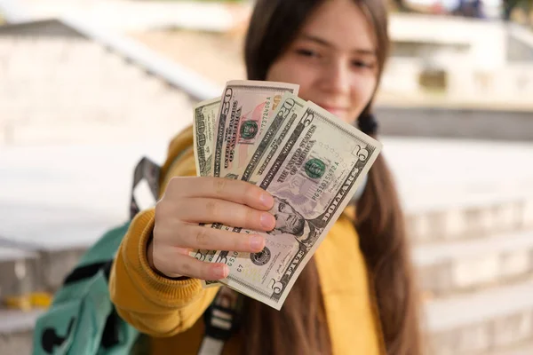 Дівчинка-підліток показує багато доларів купюр і посмішок . — стокове фото