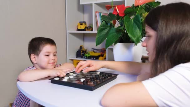 Mãe e filho estão se preparando para jogar damas, colocar damas no tabuleiro — Vídeo de Stock