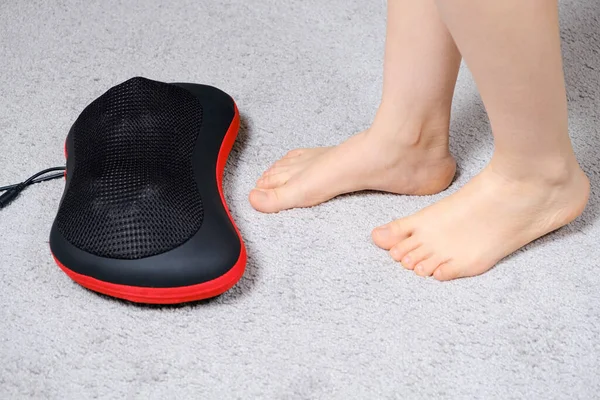 Womens feet on a massage pillow, relieving leg fatigue after a days work. — Stock Photo, Image