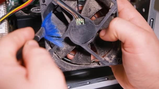 A computer master cleans the dust of the cooler of the ventilation of the system unit — Stock Video