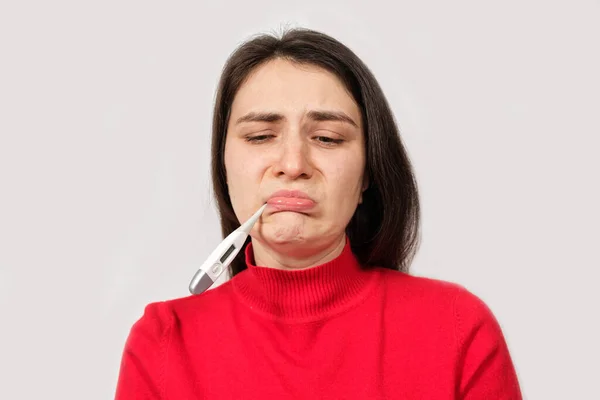 Uma mulher triste doente com um termômetro na boca, espaço de cópia para texto. — Fotografia de Stock