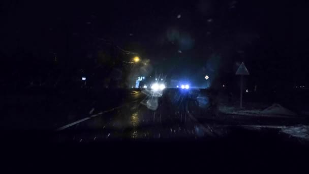 První sníh v zimě v noci, pohled z auta při jízdě, světlo reflektorů. — Stock video