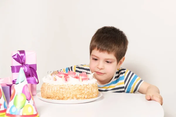 El cumpleañero apaga las velas del pastel de cumpleaños. — Foto de Stock