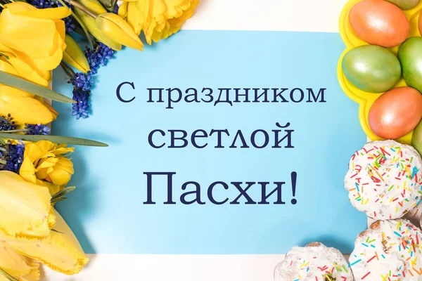 Hermosa postal con pasteles, huevos y flores con texto en ruso, traducción del ruso - Feliz Pascua, vista superior —  Fotos de Stock