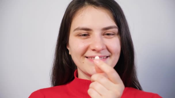Una mujer hermosa toma una pastilla, la muestra en su lengua y sonríe. — Vídeos de Stock