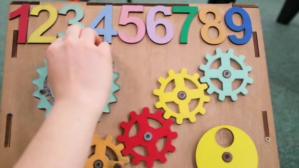 Drukke Bord voor kinderen, houten bord met nummers, tandwielen draaien. Speelkamer en de ontwikkeling van fijne motoriek en aandacht. — Stockvideo