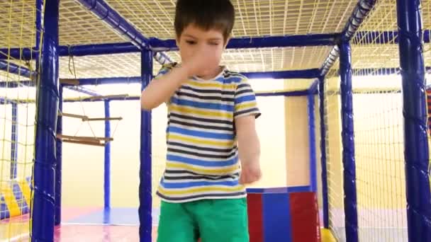 Seorang anak laki-laki berusia 4 tahun berlari melalui labirin di ruang bermain untuk anak-anak, gerak lambat menembak — Stok Video