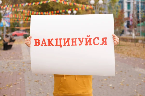A woman holds a poster with text, translated from Ukrainian: Get vaccinated — Stock Photo, Image