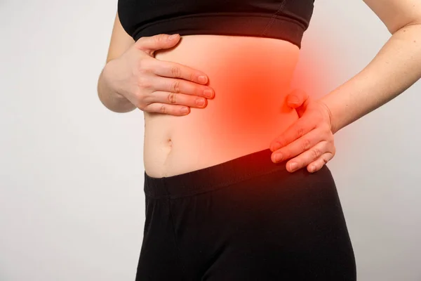 A woman shows the location of the pancreas and spleen, the large intestine. A close-up of the abdomen. — Stock Photo, Image