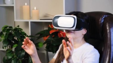 Sanal gerçeklik gözlüklü bir kadın elleri açık bir şekilde ellerini kaldırıyor..