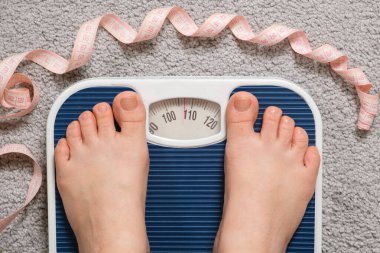 Kadınların çıplak ayaklarıyla zemin tartması ve mezura, ağırlığı 100-110 kg arasında değişiyor. Obezite, kilo kaybı ve aşırı kilo fikri.