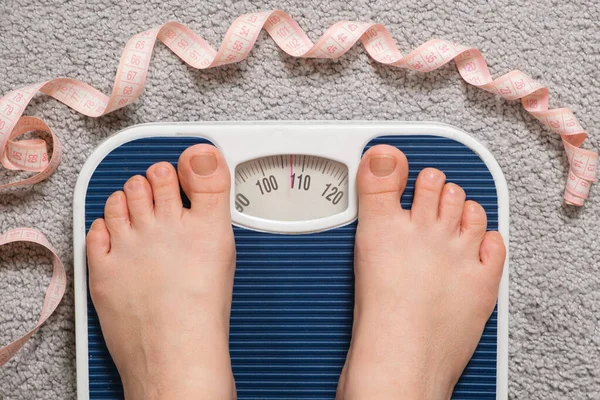 Kadınların çıplak ayaklarıyla zemin tartması ve mezura, ağırlığı 100-110 kg arasında değişiyor. Obezite, kilo kaybı ve aşırı kilo fikri.