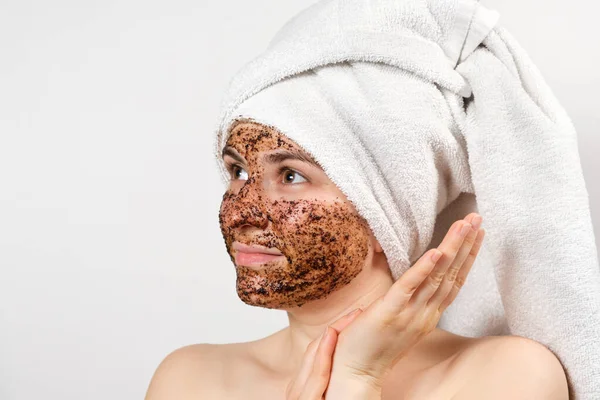 Een vrouw doet gezichtsbehandelingen, gezicht natuurlijke scrub, kijkt omhoog. — Stockfoto