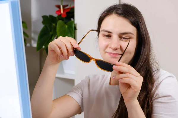 A woman holds perforation glasses to correct visual impairment. — Stock Photo, Image