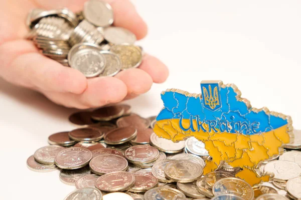 Ukraina och pengar, handen sträcker ut en handfull mynt. Internationellt bistånd till Ukraina, investeringar och företag. — Stockfoto