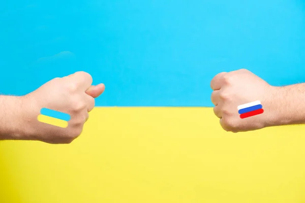 Концепция войны России против Украины - это две руки с флагами стран, фиговый жест, место для текста — стоковое фото