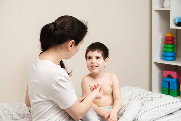 Η μαμά δίνει ένα χάπι στο παιδί, θεραπεύοντας τα παιδιά στο σπίτι. Παιδικές ασθένειες, συμπληρώματα διατροφής ή βιταμίνη D. — Φωτογραφία Αρχείου