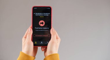 21 Mart 2022, Zaporozhye, Ukrayna. Tehlike alarmı uygulaması aktif olan birinin elindeki bir akıllı telefon. Tercümesi Ukraynaca - Hava Alarmı.