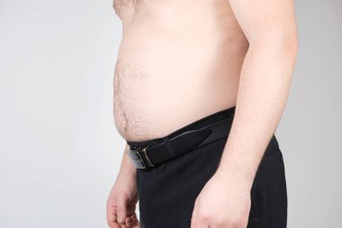 Karnı kalın, yakın plan bir adam. Erkeklerde obezite, şişkinlik