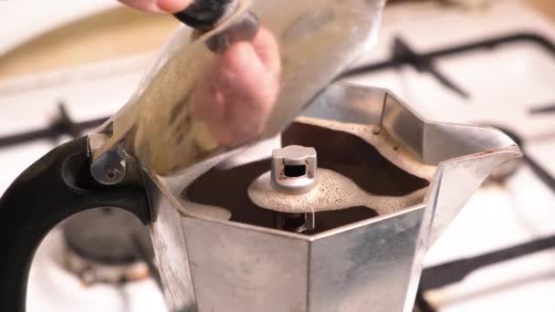 Ein Mann öffnet den Deckel einer Geysir-Kaffeemaschine, die auf einem Gasherd steht. Zubereitung von heißem aromatischem Kaffee — Stockvideo