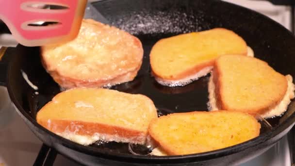 The process of cooking croutons - bread fried in an egg in vegetable oil in a cast-iron skillet, an idea for a quick breakfast. — Stock Video