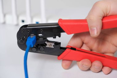 Bilgisayar ustası Vlan konektörünün bağlantısını özel bir araç sıkıştırıcı ile engeller.