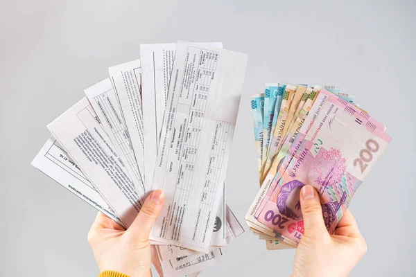 Банкноты и платежи за коммунальные услуги в гривне находятся в руках человека. Оплата газа, электроэнергии и воды в Украине. — стоковое фото